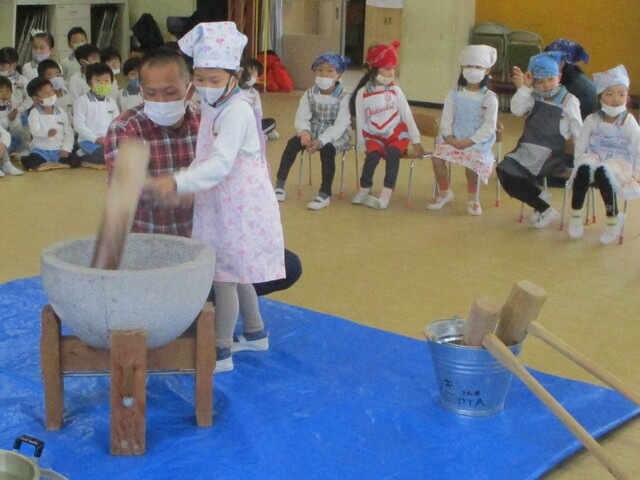 年長児が餅をついているところ