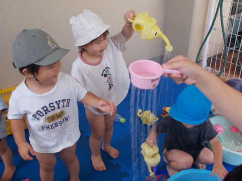 じょうろですくった水の流れを見ている様子（ひよこ）