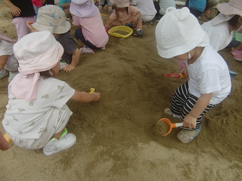 １歳児保育士と一緒に砂場あそび